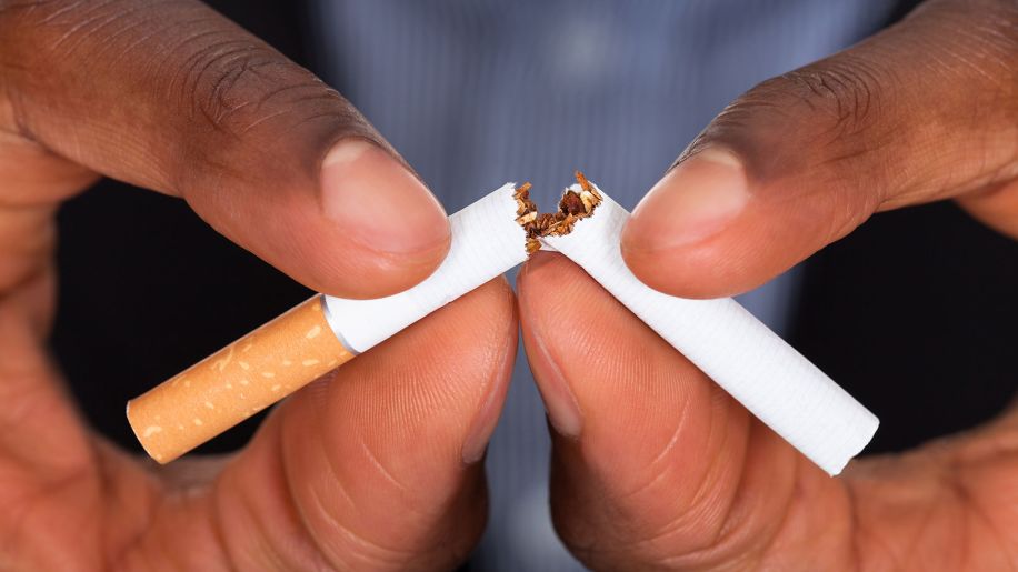 Closeup of hands breaking a cigarette in half.