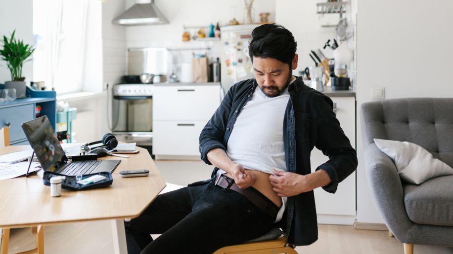 Asian man at home office with diabetes injecting insulin