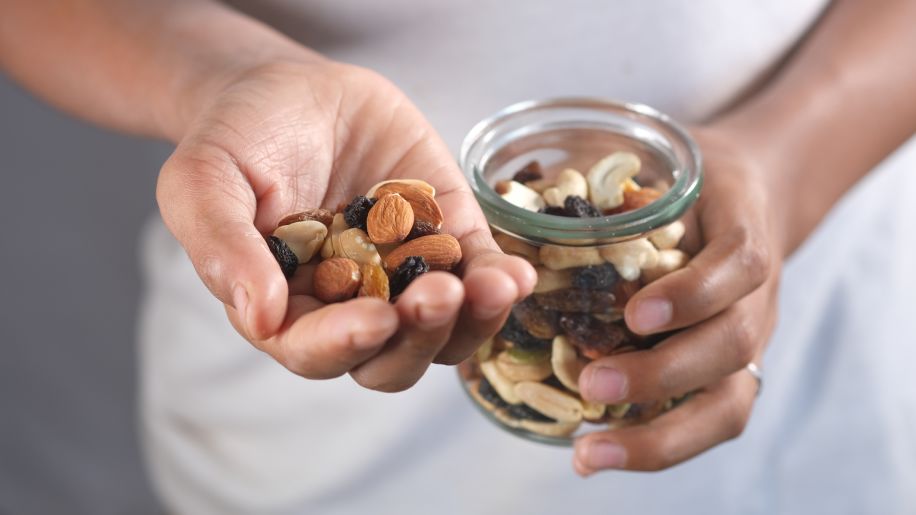 A woman eats mixed nuts.