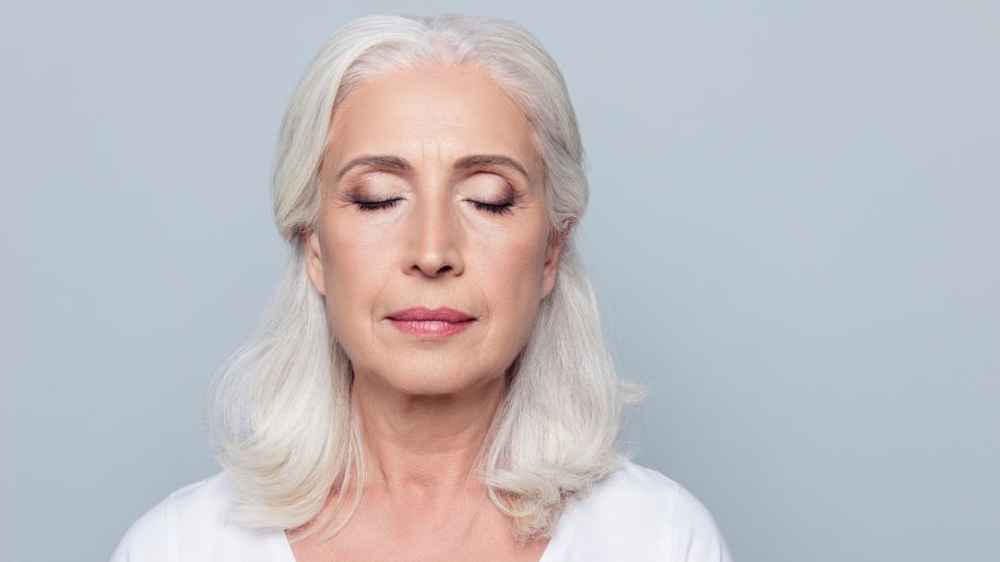 A mature woman with her eyes closed. Skin cancer can occur on the eyelids.