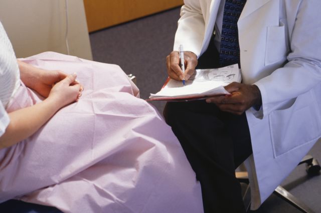 Healthcare provider filling in gynaecological chart, close-up, mid section, elevated view