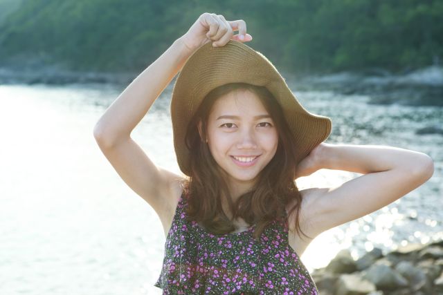 portrait of young beautiful asian woman at sea side