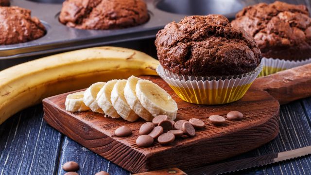 Chocolate muffins with banana on dark background. 