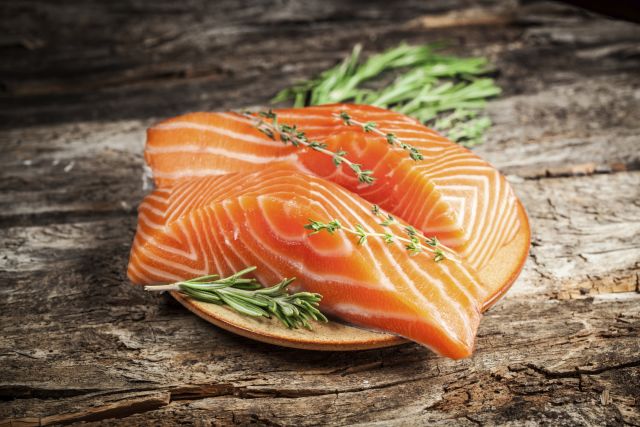 A plated piece of garnished salmon, which is rich in omega-3s, is good for skin health. 