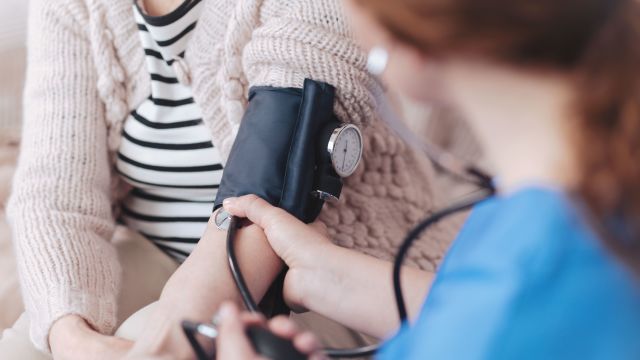 Nurse taking patient's blood pressure measurement