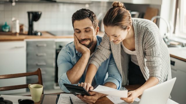 Man and woman discussing finances at kitchen table
