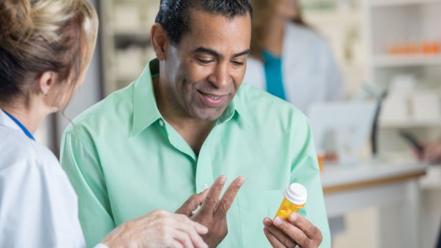 Man reading label on pill bottle