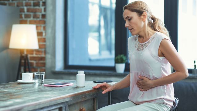 woman holding stomach in pain