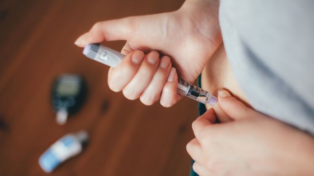 Woman giving herself an insulin injection