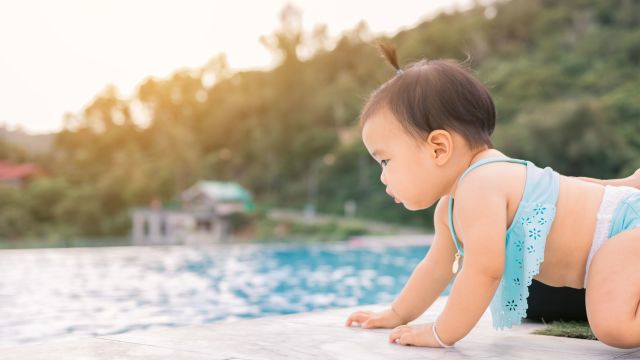 Infant crawling towards pool's edge