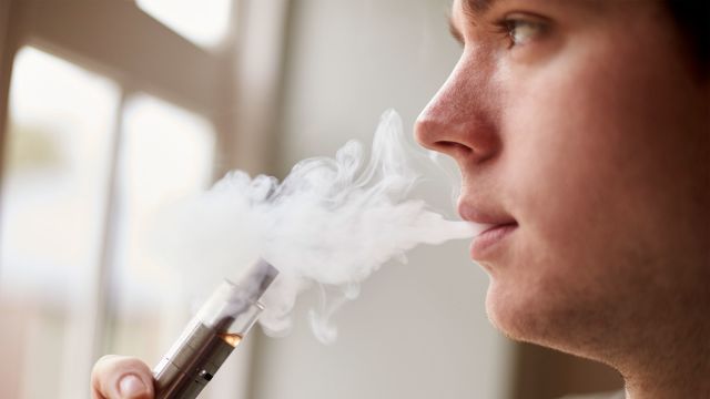 Teenager smoking an e-cigarette