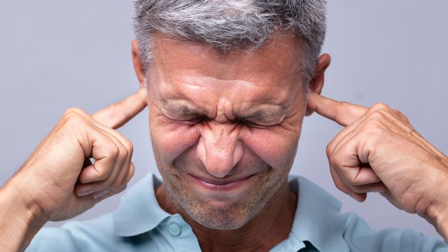 Man covering his ears with his fingers