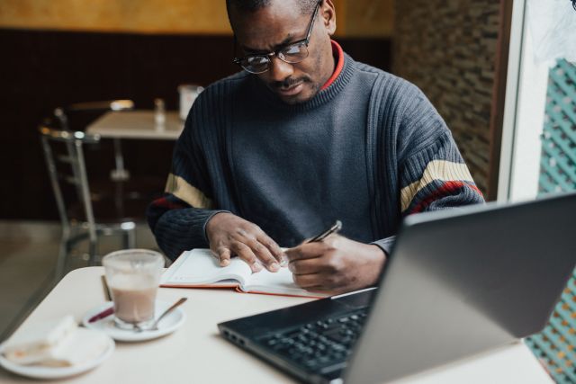 Man conducts research about cancer using laptop.