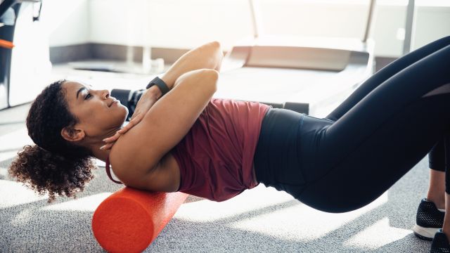 woman using foam roller to stretch