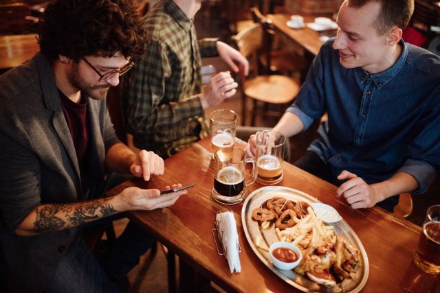 Male friends at bar eating fried foods