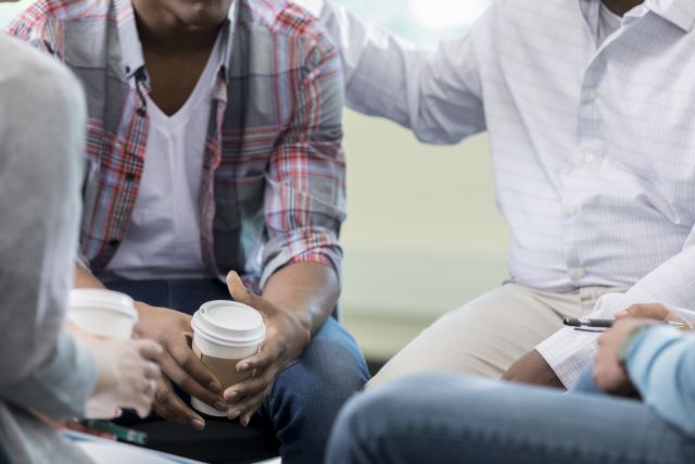 People at an Alcoholics Anonymous meeting support each other as they cut back on drinking completely.