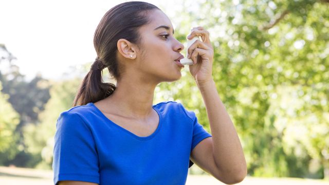 women using inhaler outside