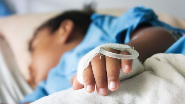 child lying in hospital bed
