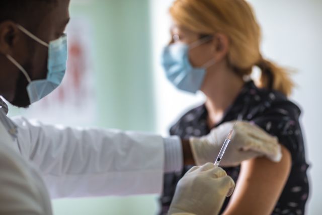 A woman gets vaccinated for the flu. The flu shot and shingles vaccine are safe to receive at the same time.