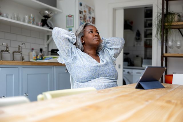 A woman struggling with a type of anxiety disorder, holds her head in her hands.