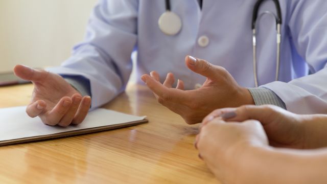 Physician explaining treatment to a patient in an office setting.