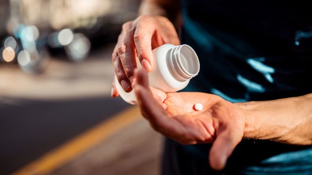 Man tipping a bottle to get medication.