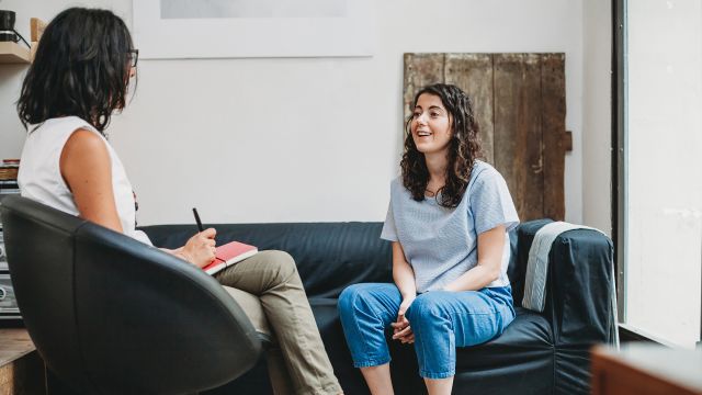 A patient speaks with her therapist in her office.
