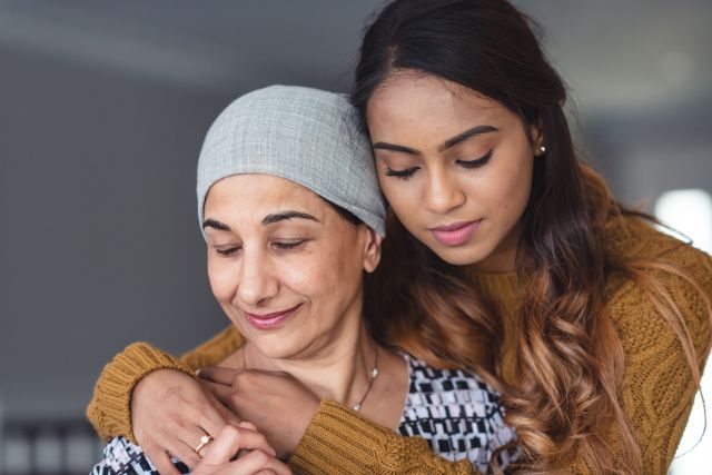 young woman hugging older one, who is wearing a headscarf