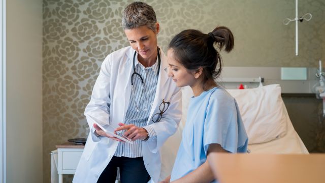 Young woman talking to doctor