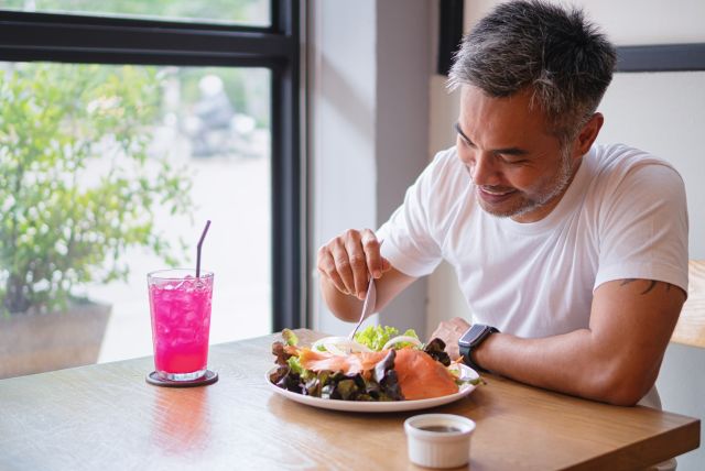 man eating salad with salmon