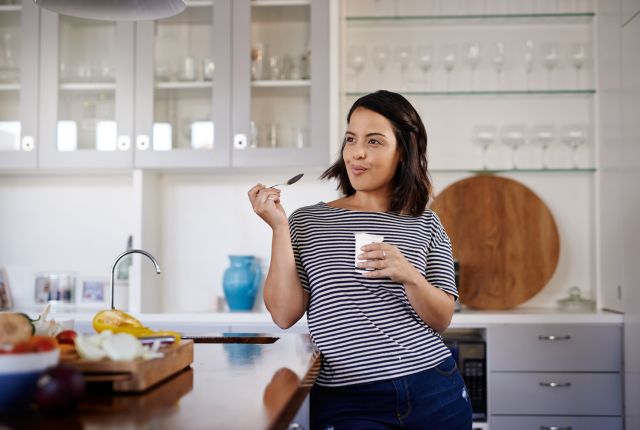 woman eating yogurt for breakfast