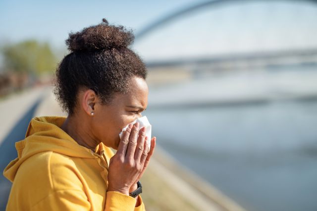 woman blowing nose during exercise outdoors