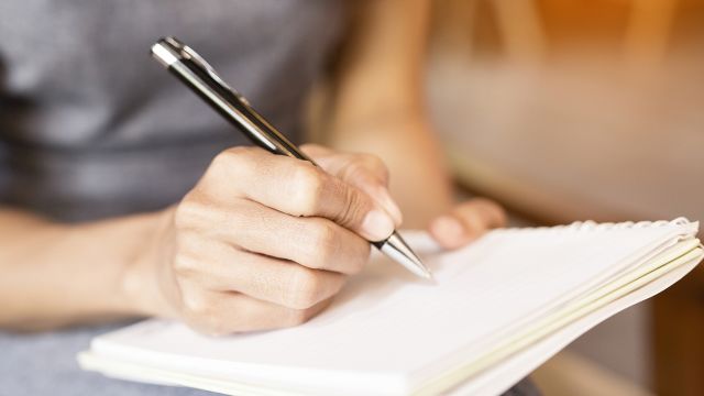 A young woman writes in a journal. If you have psoriasis, keeping a record of your experience can be a useful tool.