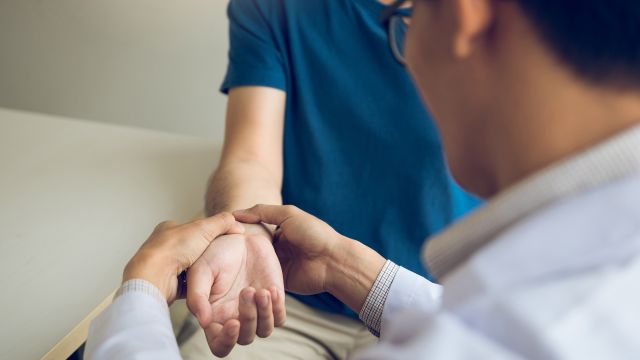 A healthcare provider examines a patient's wrist. 