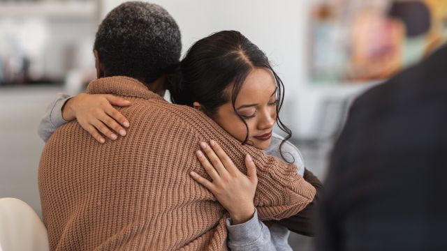 Two women embrace at a support group for people with lupus.