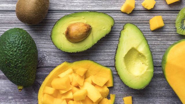 Avocados, kiwis, and mangoes on a cutting board. A healthy diet is important when managing TED.