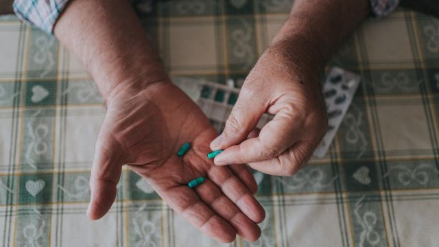 A man examines pills. Oral medications called targeted therapies are often prescribed for chronic lymphocytic leukemia.