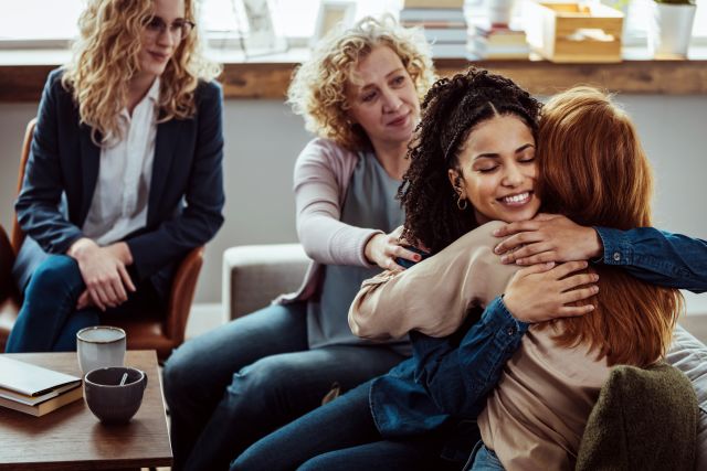 A group of women support another woman in a support group who is experiencing anxiety. 