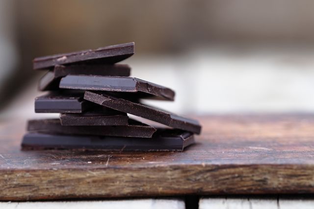 stacked pieces of dark chocolate with nuts