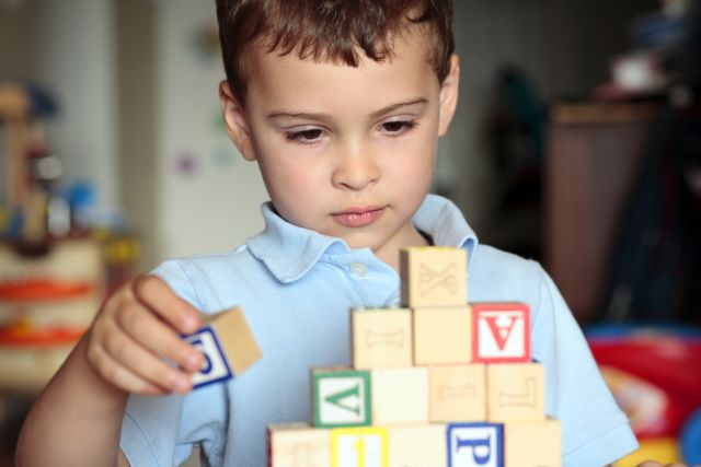 young boy with autism stacking blocks
