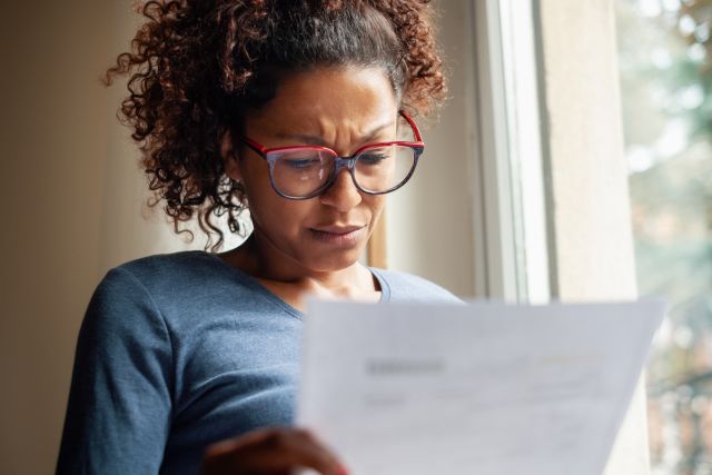 Closeup of a woman reviewing her finances looking worried