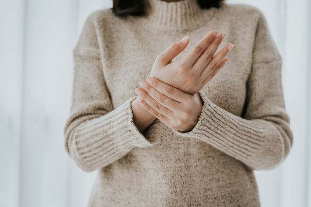 Woman holds her wrist suffering from joint pain