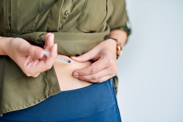Closeup shot of an unidentifiable woman injecting a biologic for psoriasis into her stomach