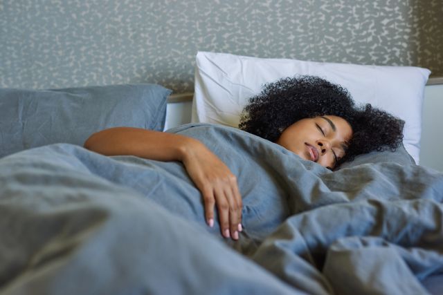 young woman sleeping peacefully in bed in the morning light