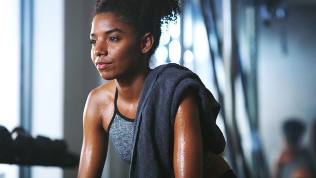 sweaty person pausing during workout at a gym