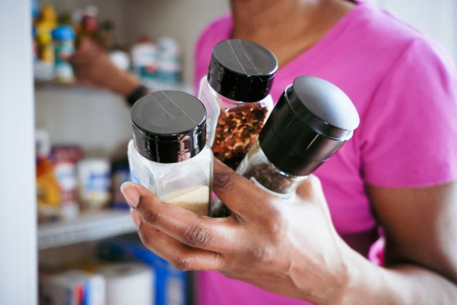 woman taking spices out of pantry