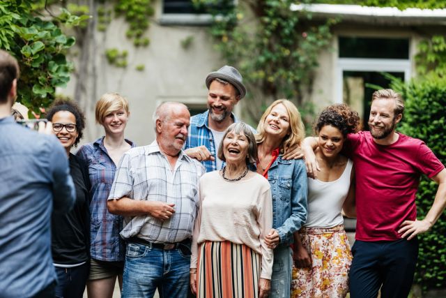 a multi-generational family gathers together on a happy special occasion to get together and take a photograph