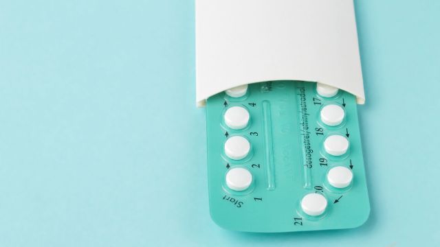 A birth control pack on a teal background.