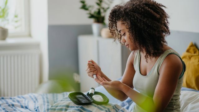 A teenage girl checks her glucose levels with a continuous glucose monitor.