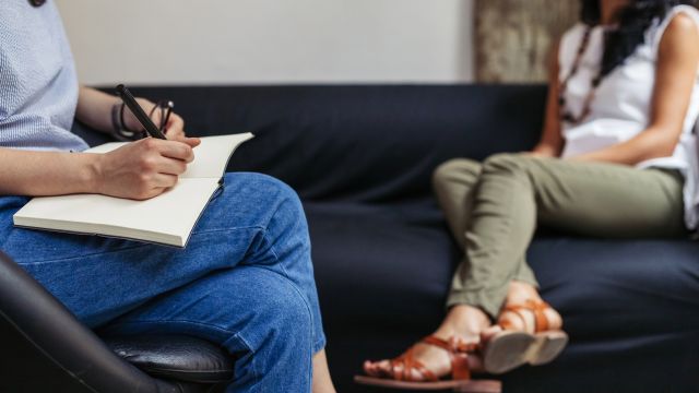 A therapist takes notes during an appointment with a young woman. Therapy is an important component of managing bipolar disorder and coexisting mental health conditions.